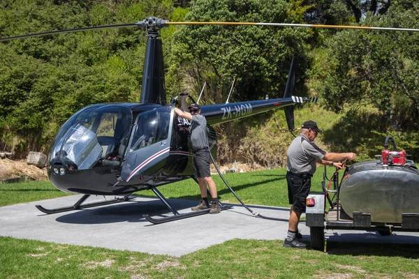 Two men fueling a helicopter